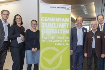 6 Menschen stehen neben einem Kampagnenschild
