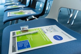 Ein Blatt Papier samt Stift auf einem Stuhl
