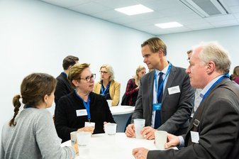 4 Personen beraten sich an einem Tisch